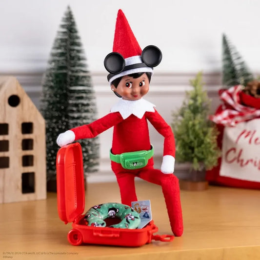 Elf on the Shelf with a suitcase and donut toy in a festive setting