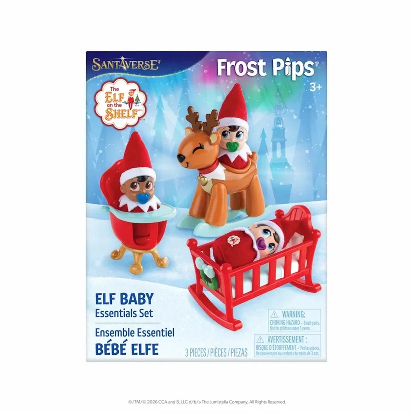 Santaáverse The Elf on the Shelf Frost Pips Elf Baby Essentials Set toy packaging, featuring illustrations of elf toys including an elf baby in a red crib, an elf in a high chair, and an elf with reindeer antlers on a snowy blue background.