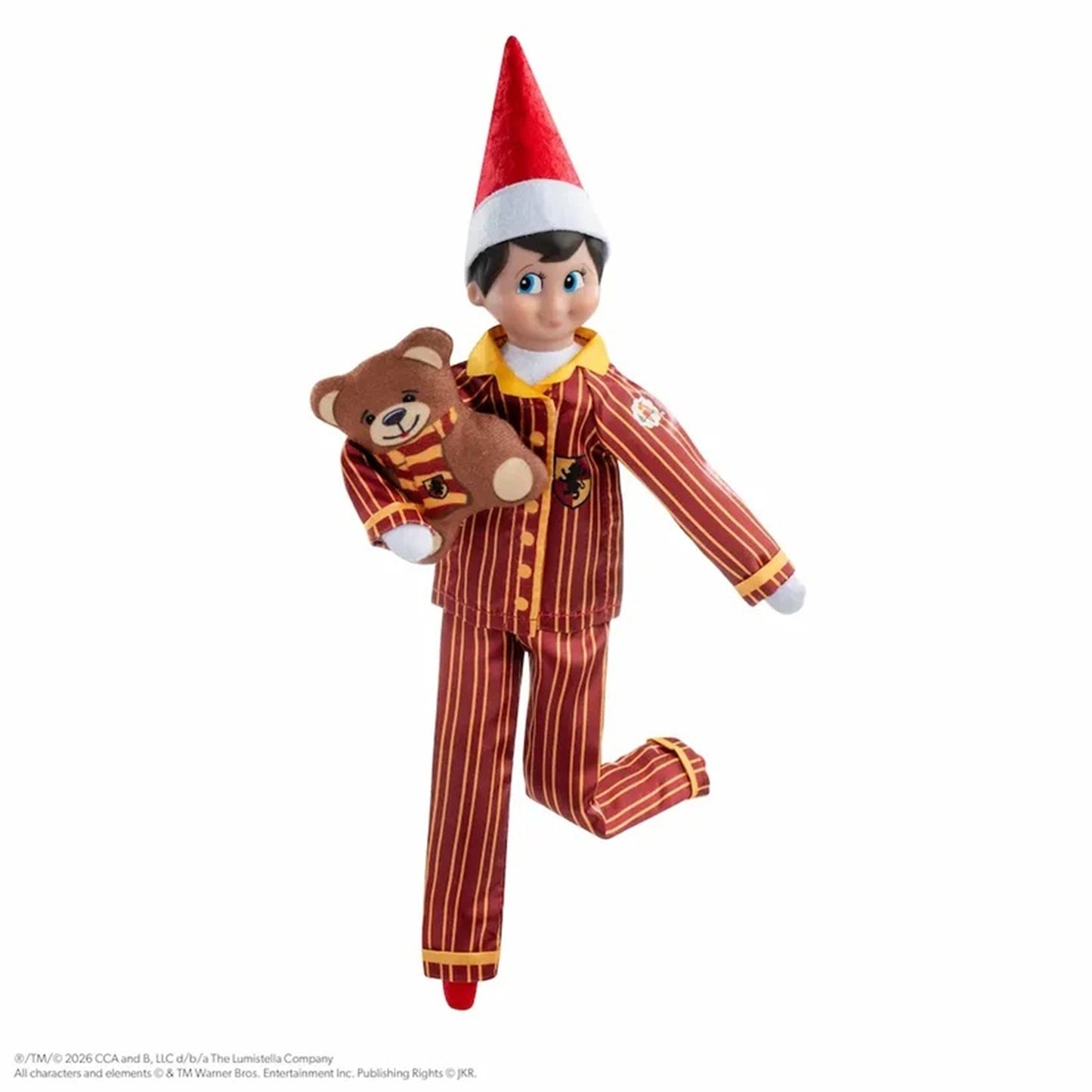 Elf on the Shelf toy figure wearing red and gold striped pajamas and a red Santa hat, holding a brown teddy bear against a plain white background.