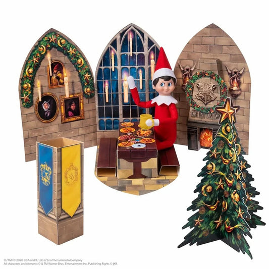 A Harry Potter-themed elf on shelf holiday display set featuring three arched backdrop panels with Hogwarts scenes, a miniature table with food, a blue and gold banner, and a decorated Christmas tree, all arranged on a white background.